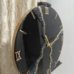 "A stylish resin wall clock featuring a black and gold color palette, perfect for modern and luxurious interiors."