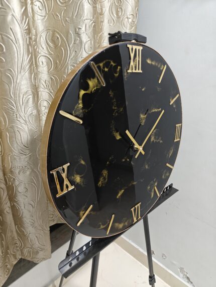 "A stylish resin wall clock featuring a black and gold color palette, perfect for modern and luxurious interiors."