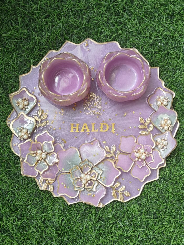 "A 10-inch resin pooja platter with intricate designs, glossy finish, and compartments for pooja essentials like diya and incense."