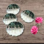 "Handcrafted black and silver resin coasters featuring ocean-inspired designs, ideal for modern and elegant table settings."