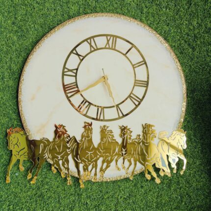 Elegant white resin base with golden textured rim Premium gold-tone Roman numeral dial Striking seven-horse cut-out design for symbolic and aesthetic appeal Handcrafted finish with luxury detailing Smooth, silent quartz movement for a peaceful ambiance Ideal for modern, traditional, or Vastu-inspired interiors