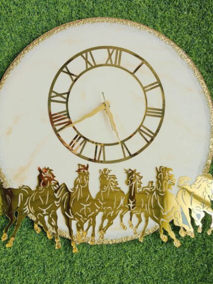 Elegant white resin base with golden textured rim Premium gold-tone Roman numeral dial Striking seven-horse cut-out design for symbolic and aesthetic appeal Handcrafted finish with luxury detailing Smooth, silent quartz movement for a peaceful ambiance Ideal for modern, traditional, or Vastu-inspired interiors